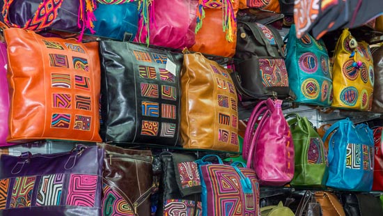 9. Se ve unestán y vitrinas llenas de bolsos artesanales de diferentes colores.