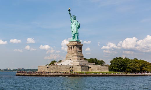Vista frontal de la estatua de la libertad, ubicada en una isla en medio del río Hudson