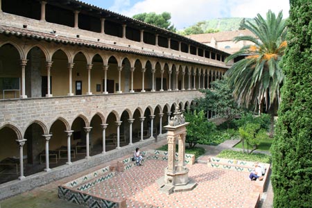 Vista aérea del patio de un monasterio, con un edificio de grandes torres y largos pasillos