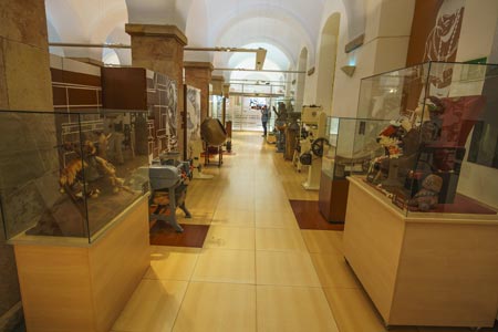 Interior de una de las salas del Museo de Chocolate, con pisos en madera, grandes columnass y figuras de chocolate dentro de cajas de cristal