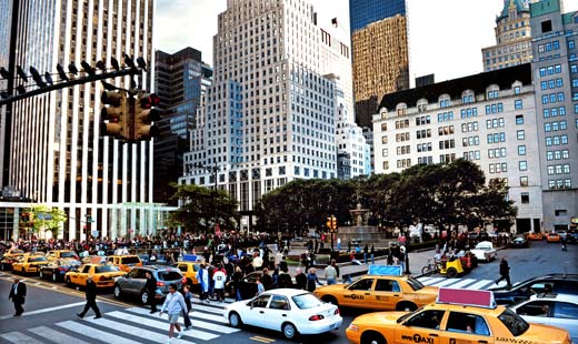 Una intersección de una de las calles más concurridas de Nueva York,con personas cruzando entre los carros