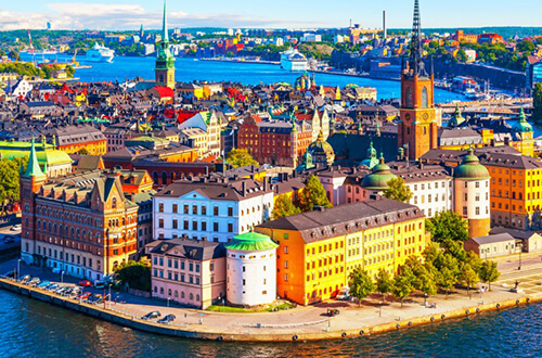 Panorámica de la ciudad de Estocolmo y sus 14 islas rodeadas de mar y conectadas por puentes. Se ven árboles y sus diferentes construcciones