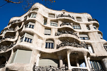 Imagen en ángulo contrapicado, de un edificio de 6 pisos hecho a base de piedra 
