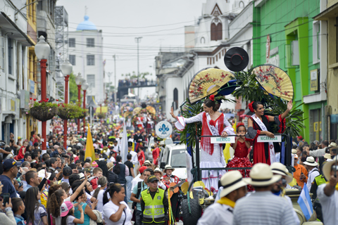 desfile de carrozas adornadas en las que van las reinas de la Feria