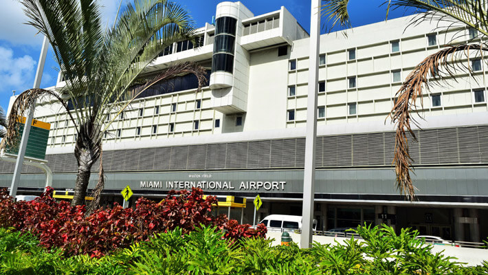 Vista de la entrada del Aeropuerto Internacional de Miami con dos palmeras al frente