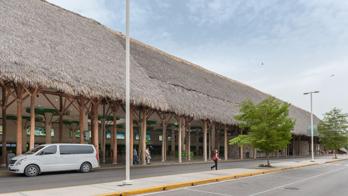 Terminales al aire libre del aeropuerto de Punta Cana con techos cubiertos de hojas de caña