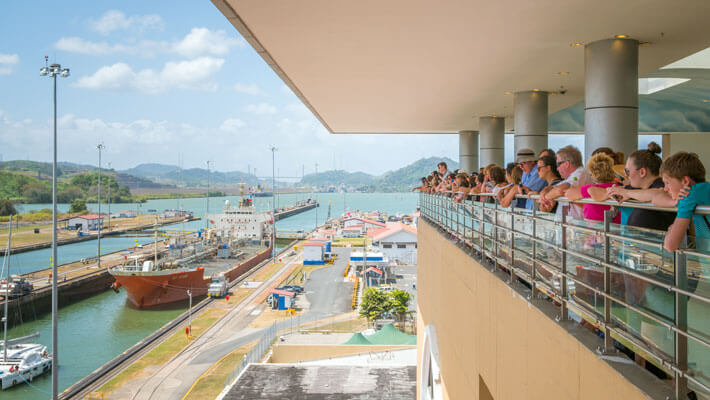 Grupo de turistas observando desde el mirador el paso de los barcos por las esclusas del Canal de Panamá