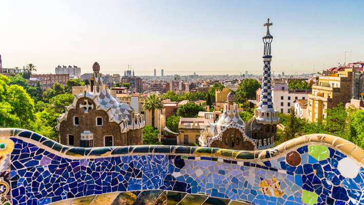 Panorámica de la ciudad de Barcelona desde el Parque Güell, en el que se alcanza a ver algunos detalles de decoraciones con baldosas coloridas
