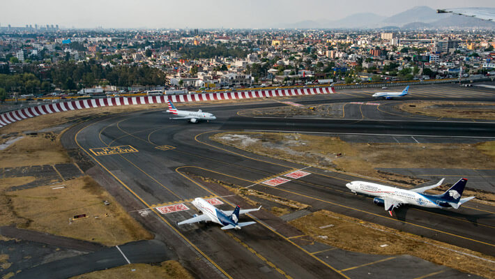 Están 4 aviones en carreteo de Aeroméxico y de fondo se ve la ciudad de México 