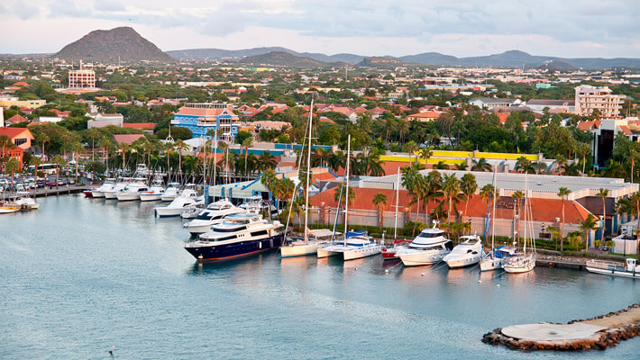 Puerto principal de Aruba, de fondo la ciudad de Oranjestad y parte del muelle con embarcaciones